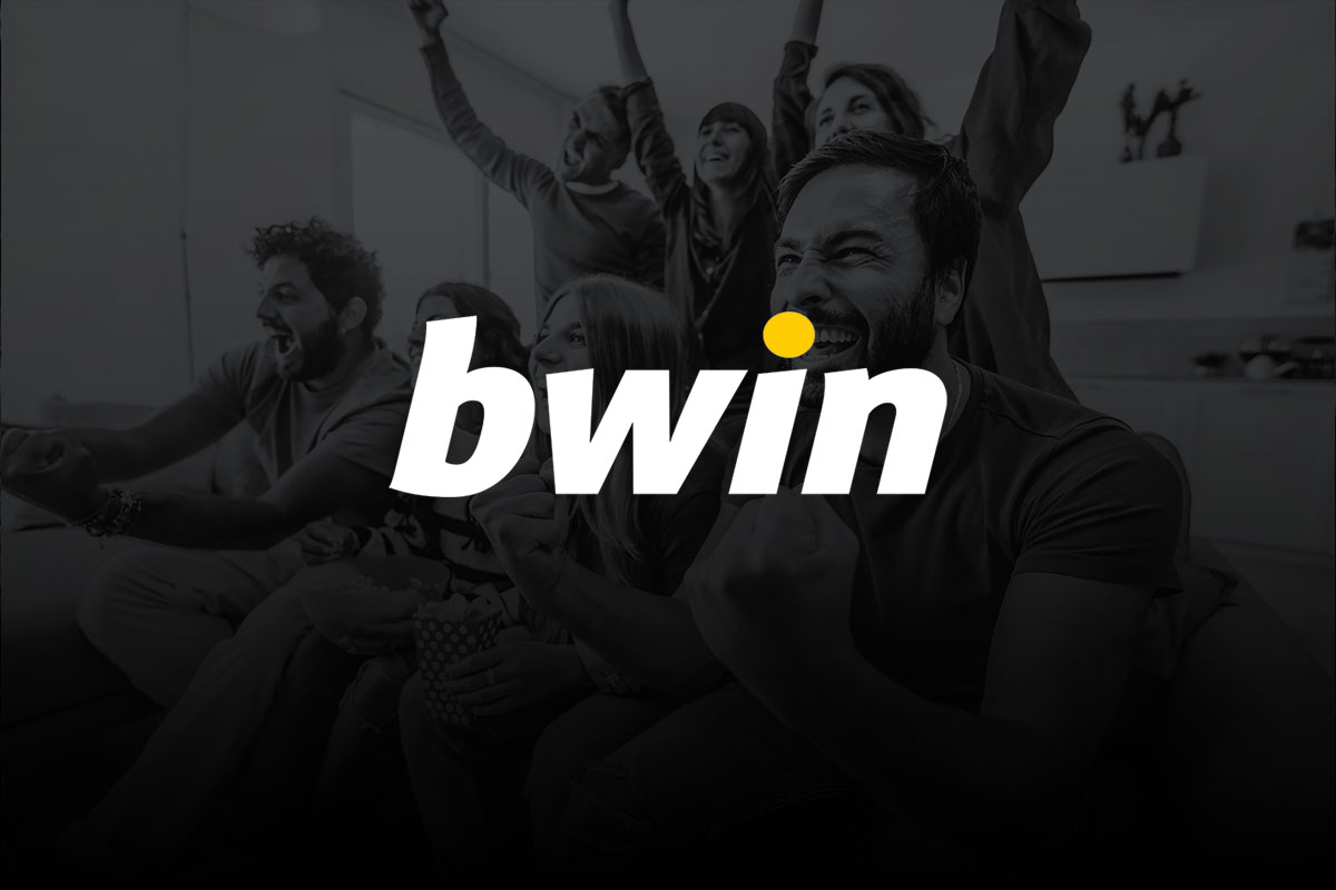 Imagem de divulgao da bwin com o logo em tons de branco e amarelo sobreposto a foto de fundo em preto e branco de torcedores em uma sala celebrando. 